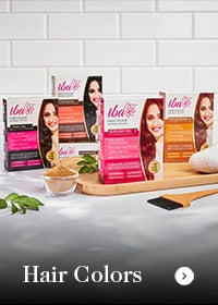 Hair color products with packaging and tools on a white surface.